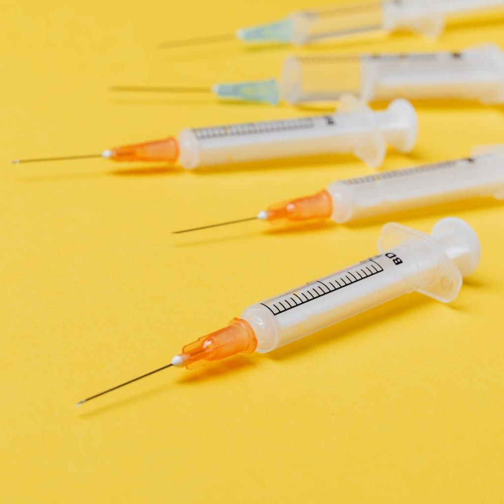 Syringe injectors placed on yellow surface